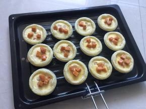 烤制基本凝固时取出，在蛋挞上放入红薯粒，然后放入烤箱中继续烤10分钟