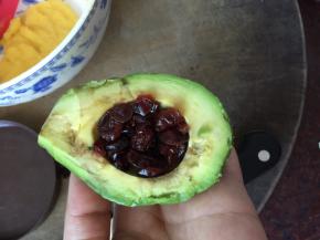 牛油果去皮去核后刷上柠檬汁，然后放入泡发好的蔓越莓