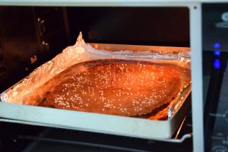 然后拿出来把肉片倒扣，把另一面刷上蜂蜜水，洒上芝麻，把烤箱调低至165度再烤10分钟