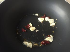 锅中少许油烧热，加入蒜和干辣椒煸香