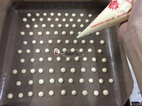 9. 裱花袋剪一小口，把蛋黄糊挤在烤盘上，波点大小按个人喜好的来，（我用的是东菱烤立方放在最低层，上火150度，下火120度，3分钟）