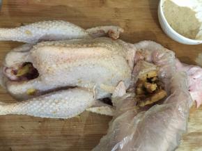 4. 先用混合好的盐粉，适量的把整只鸡都抹一遍，再把捣碎的南姜来擦拭整只鸡，抹擦好之后把所有的南姜都塞进鸡的肚子里