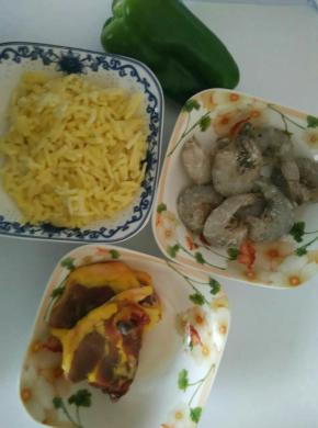 在等待面团发酵的时候，鸡肉切小丁，加入少许盐，黑胡椒碎抓匀腌制一会儿
大虾去头皮剔除虾线洗净备用，青椒切成青椒圈备用
炒锅里放入少许食用油烧热，放入腌制好的鸡丁小火煸炒至变色盛出
.接着发入青椒圈小火煸炒出水分后盛出（这样做是为了防止披萨在烘烤的过程中产生过多的水分而影响成品的口感）把大虾也放入锅里小火煸炒熟盛出备