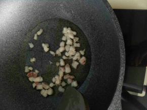 4、米饭快煮好时，锅烧热倒入适量玉米油，先下肥肉丁逼出肥肉的油。