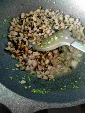 6、翻炒均匀倒入香菇丁继续炒。