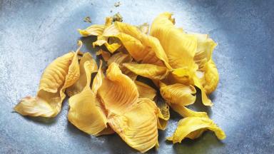 把洗净晒干的鸡内金倒入锅内，利用锅体余温焙焙。