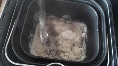 按和面键，边倒开水馒头机边搅拌。