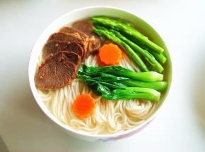 表面铺上刚刚过水的时蔬，再放上几片香味诱人的牛肉片，鲜美香醇的牛肉汤面就做好了，开吃···
