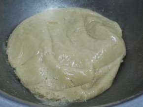 向搅匀的糖浆中筛入广式月饼预拌粉，用刮刀拌匀成团，静置30分钟。