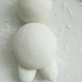 头部和身体紧挨着摆放一起(中间可以抹水使沾合正牢固)把刚好做好的大白的小胖腿放到大白身体下边合适位置固定好