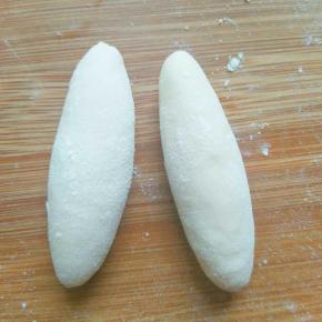 取两个各10克的面包，搓成如图的形状(一头略尖)