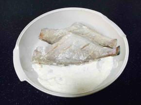 把橡皮鱼的两面都蘸上面粉，并轻轻拍打几下，把表面多余的面粉拍下去。