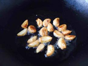 锅里留适量的底油，中火，放入蒜粒煎制约6分钟左右，蒜粒呈金黄色。