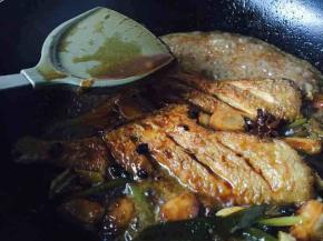 用铲子往鱼身上淋汤汁，改大火炖5分钟收汁，收汁时要不时地端着锅离火转圈晃动，避免粘锅，汁收干，关火。
第17步骤、18步骤不用盖锅盖。