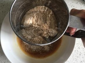 熟黄豆粉与低筋面粉混合均匀倒入面粉筛中，过筛加入到蛋黄红糖液中