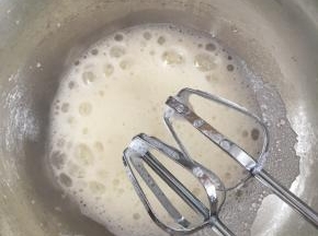 用电动打蛋器打发至粗泡状态，加入1/3的细砂糖，继续中速打发