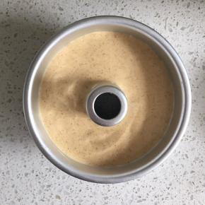 把翻拌好的蛋糕糊倒入6寸中空模具中，轻轻在桌上磕一下，震出大气泡