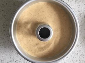把翻拌好的蛋糕糊倒入6寸中空模具中，轻轻在桌上磕一下，震出大气泡