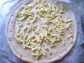 披萨饼坯上撒上马苏里拉奶酪；