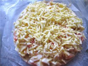 上面再撒上奶酪碎，然后放入预热好210度的烤箱内，烘烤12-15分钟。