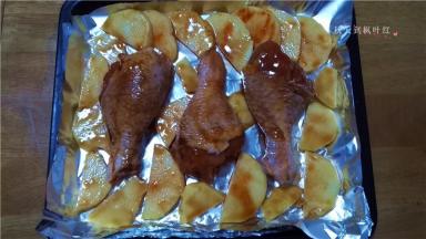 烤盘铺上锡纸，将鸡腿放入烤盘内，周围码放上土豆片；