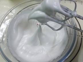 9. 中速打发至蛋白变得泡沫细腻，打至蛋白霜拉起的大弯钩下弯就说明发好了，（如图）千万别打过了，如果打发偏硬的话，蛋糕卷在卷的时候会裂哦
