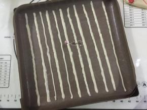 11. 裱花袋剪一小口，把蛋黄糊挤在烤盘上，挤什么样的纹路可按各人喜好，挤好送进烤箱中层170度2分钟