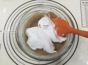 15. 再挖1/2的蛋白霜进蛋黄糊中，用刮刀从盆底由下向上快速翻拌