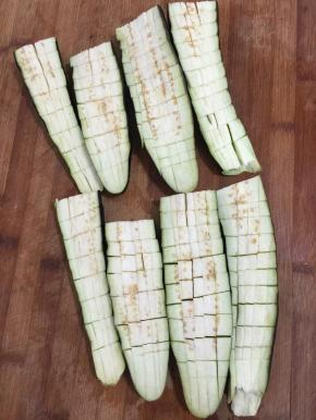 茄子去蒂清洗干净后切成两段，再对半切开，把茄子切成网格状，注意底部不要切断了！