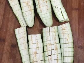 茄子去蒂清洗干净后切成两段，再对半切开，把茄子切成网格状，注意底部不要切断了！