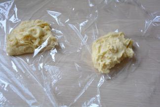 取两块保鲜膜，将面团分成两等份，放在保鲜膜上