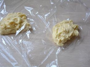 取两块保鲜膜，将面团分成两等份，放在保鲜膜上