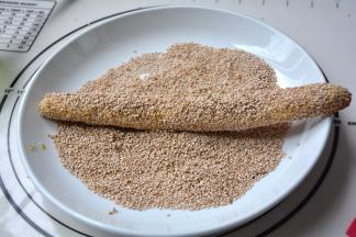 放在白芝麻里滚一下，再用手将芝麻压实