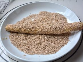 放在白芝麻里滚一下，再用手将芝麻压实