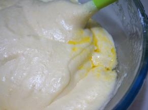 将晾凉的黄油牛奶液顺着盆壁倒入面糊中