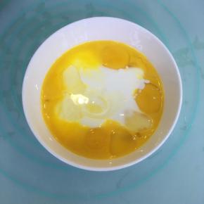 玉米油和酸奶混合，加入蛋黄，用蛋抽搅拌均匀。