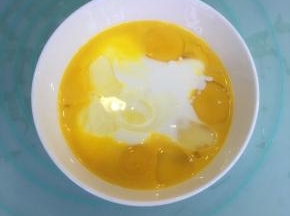 玉米油和酸奶混合，加入蛋黄，用蛋抽搅拌均匀。
