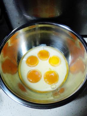 将蛋黄和蛋清分离在两个无水无油的盆中，蛋黄盆中加入牛奶和玉米油，搅拌均匀