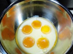 将蛋黄和蛋清分离在两个无水无油的盆中，蛋黄盆中加入牛奶和玉米油，搅拌均匀