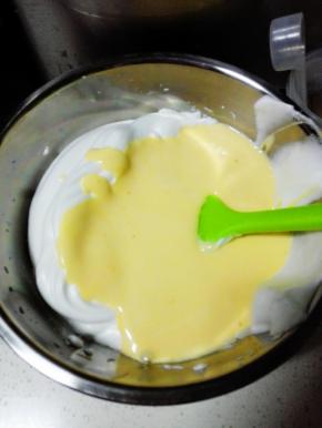 将蛋黄液全部倒入蛋白霜中，翻拌均匀