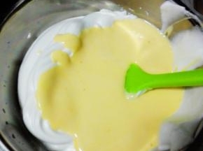 将蛋黄液全部倒入蛋白霜中，翻拌均匀