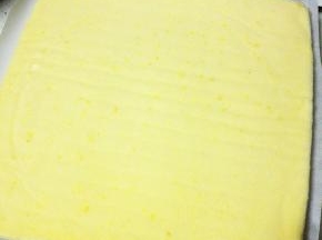 待蛋糕体至温热，取一张新的油纸还在蛋糕体上，然后迅速翻面，撕掉原来的油纸，切掉上下两端蛋糕（少许）