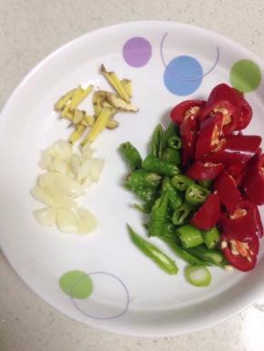 脆骨在压的时候，把青红椒洗净切小段，姜切丝，大蒜略拍切碎备用