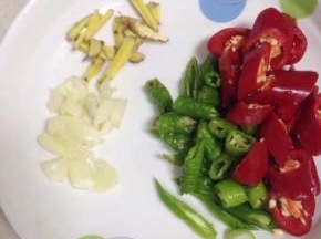 脆骨在压的时候，把青红椒洗净切小段，姜切丝，大蒜略拍切碎备用