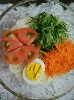 上面依次放上黄瓜丝，胡萝卜丝，鸡蛋，西红柿