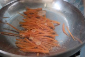 锅里烧开水，焯下胡萝卜丝。大约两分钟，捞出放凉。