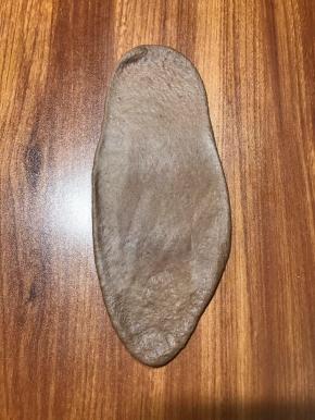 取棕色面团按扁，擀至长条，按出空气