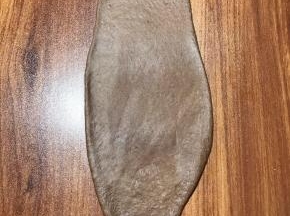 取棕色面团按扁，擀至长条，按出空气