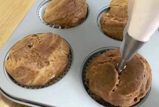 用裱花袋将奶油从泡芙上口挤入到泡芙中，此处用的是专门填泡芙内陷的裱花嘴。