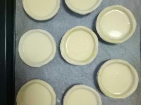 加入提前室温解冻的蛋挞皮中，八分满（这个分量是九个的，家里只剩八个）放在烤盘上